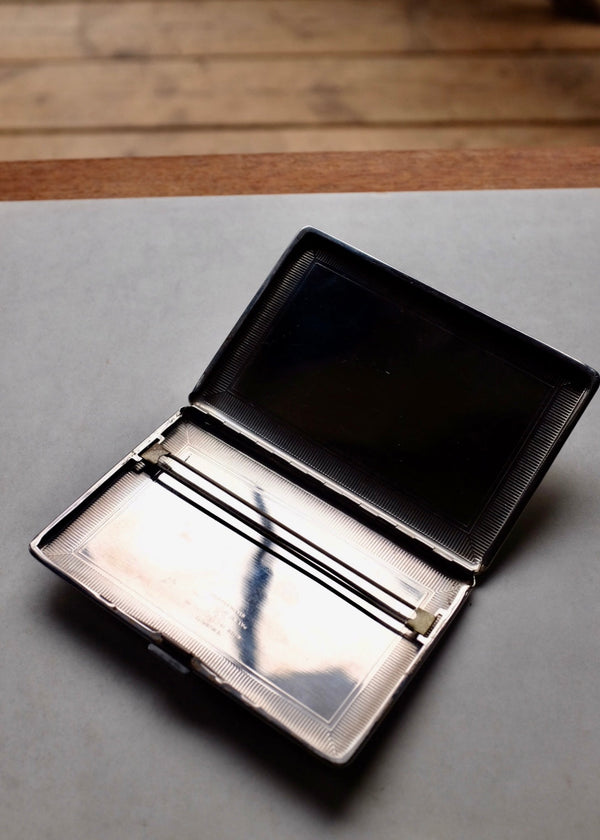 Black leather wallet on a gray surface with a wooden background