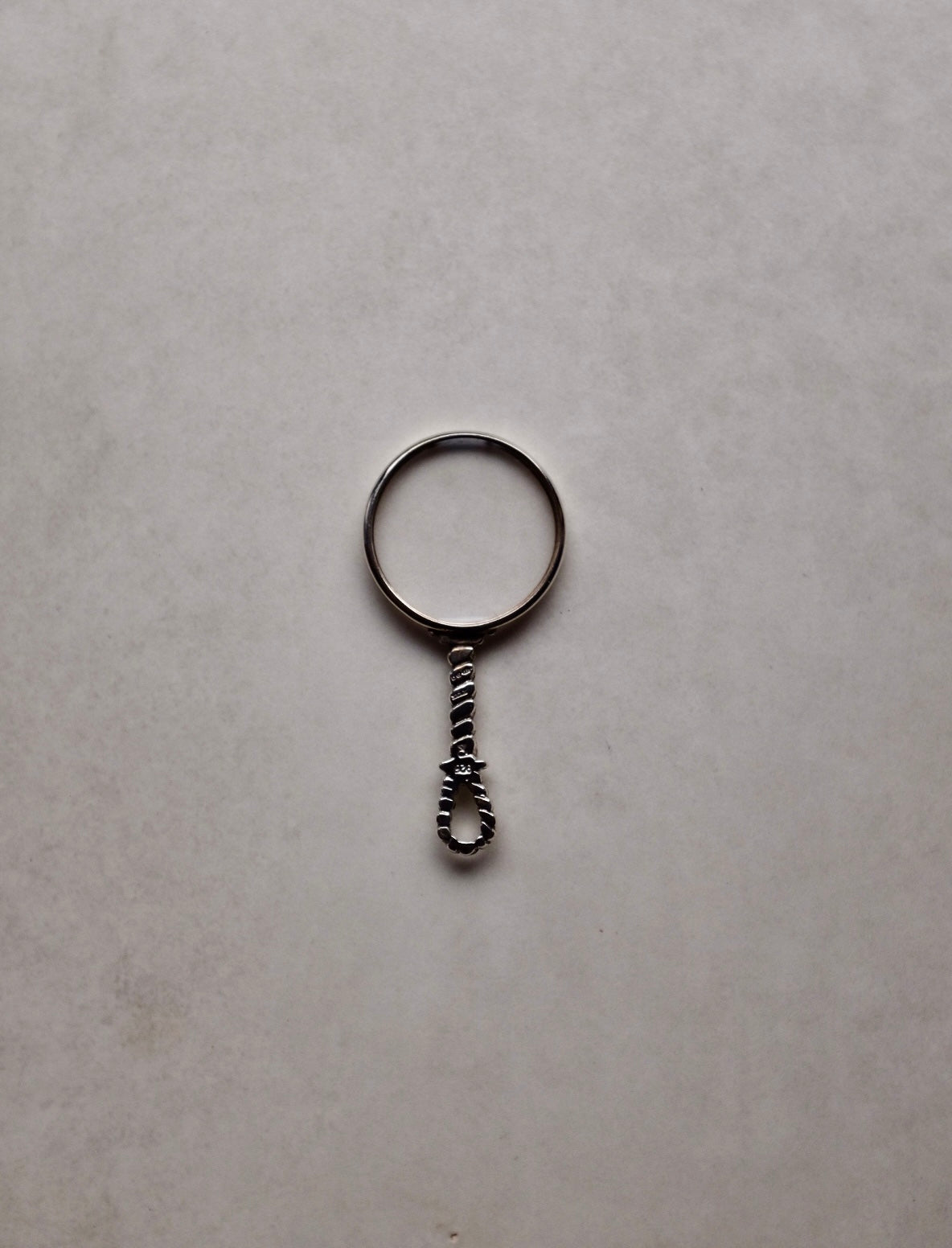 Small magnifying glass charm on a light gray background