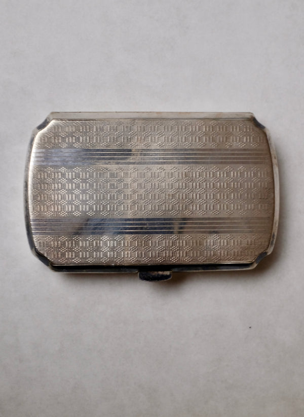 Silver textured belt buckle on a light gray background