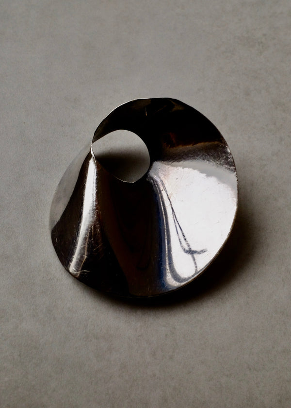 Silver ring with a unique design on a gray background