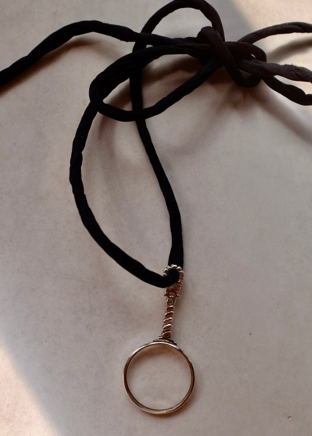 Necklace with a circular pendant on a beige background