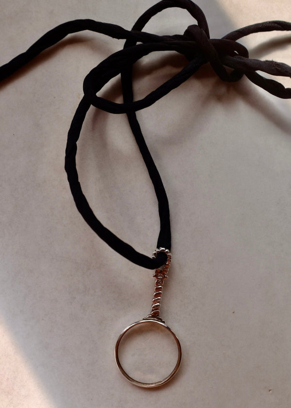 Necklace with a circular pendant on a beige background