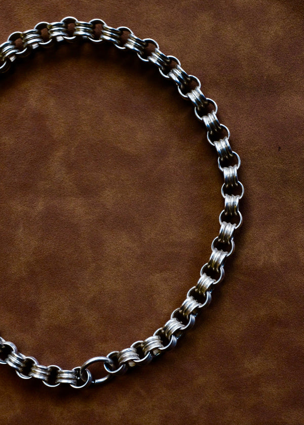 Silver chain  on a brown leather background