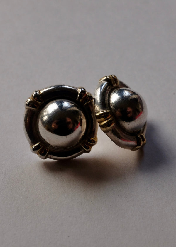 Pair of silver earrings on a gray background