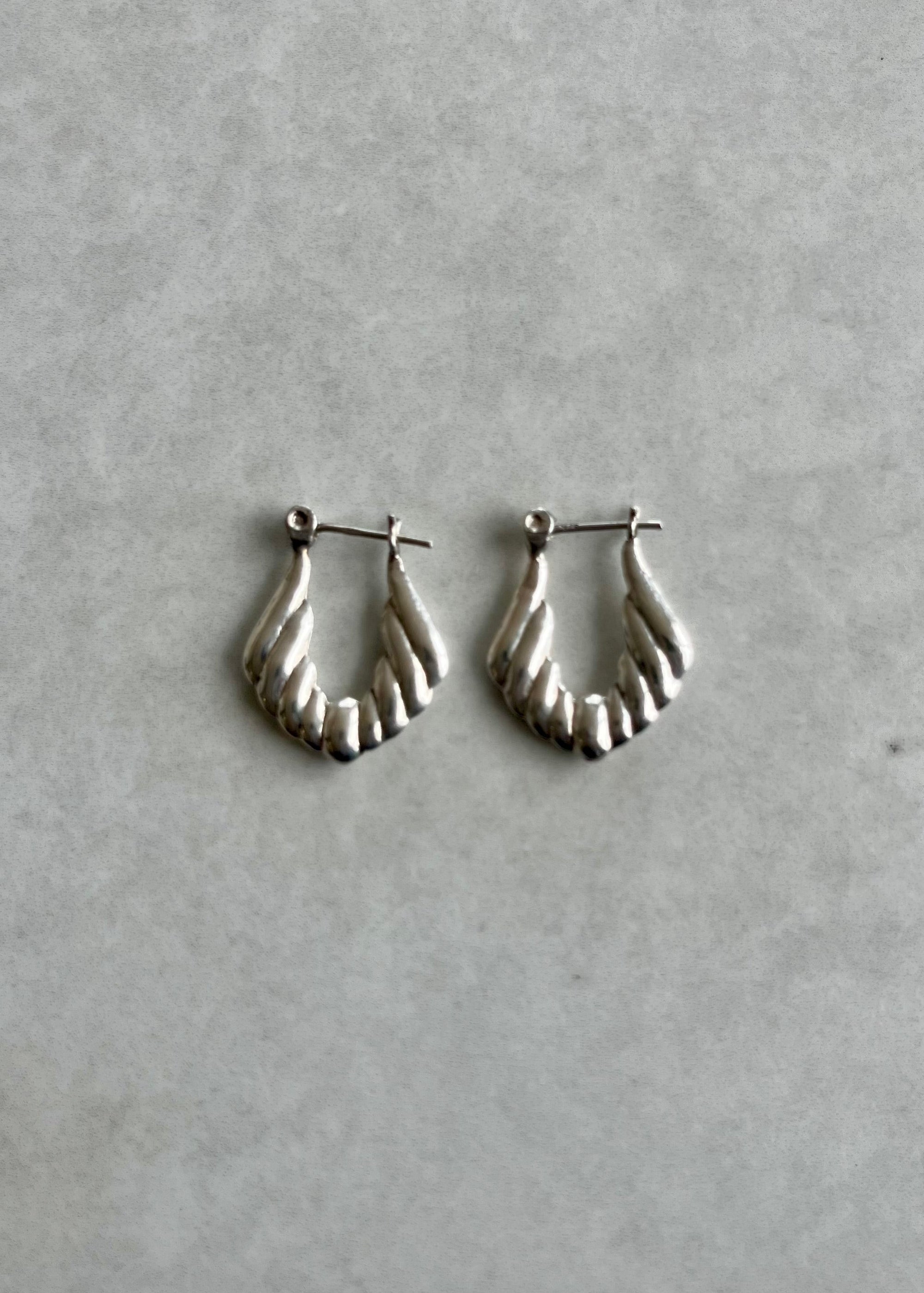Silver hoop earrings on a gray background