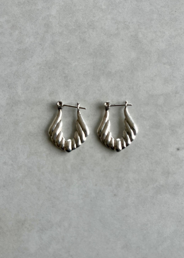 Silver hoop earrings on a gray background