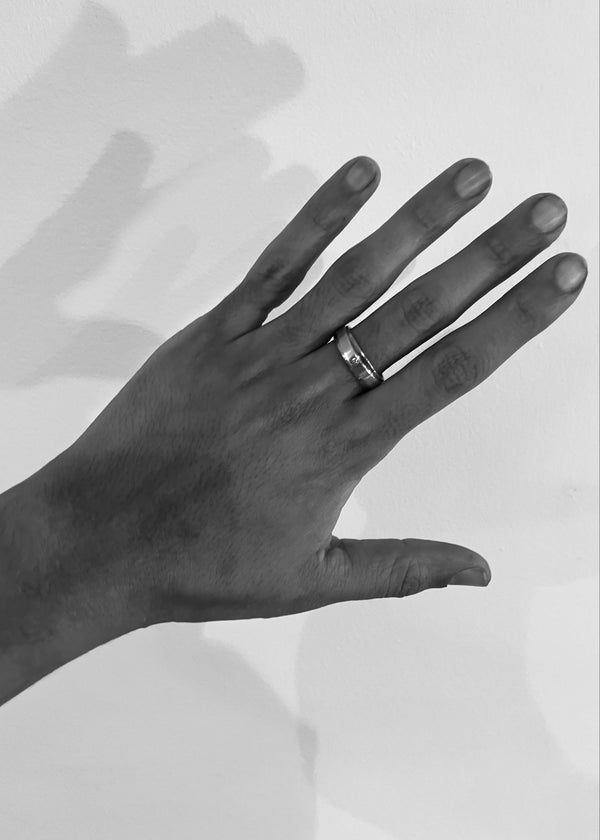 Hand wearing a ring on a plain background