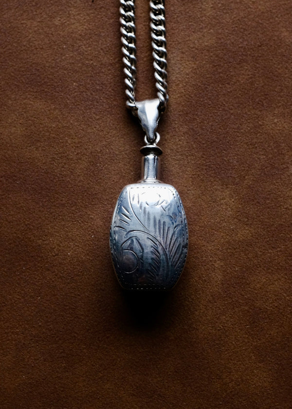 Silver pendant necklace on a brown leather background