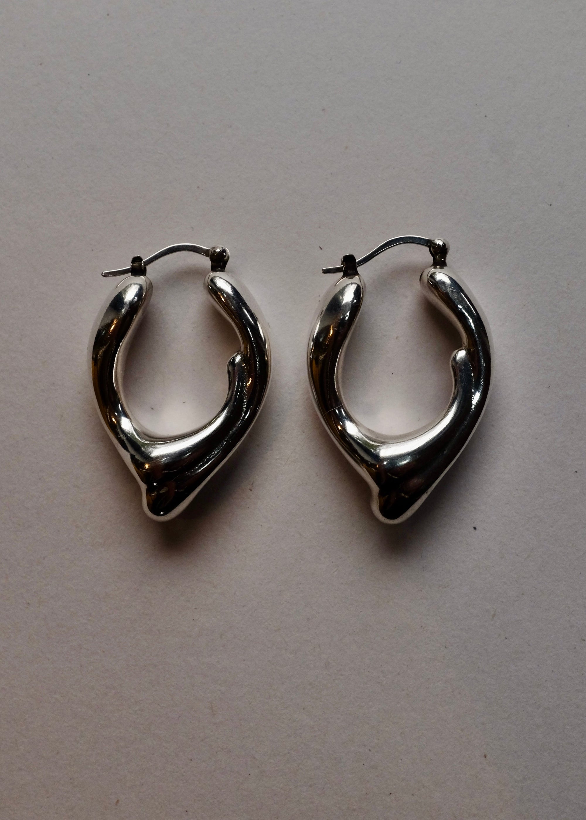 Pair of silver hoop earrings on a light gray background